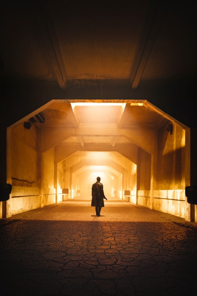 Person walking through a brightly lit tunnel